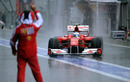 Fernando Alonso returns to the pits amidst torrential rain