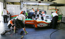 Force India mechanics work on the car of JR Hildebrand in the team gararge