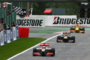 Lewis Hamilton takes the chequered flag from Mark Webber and Robert Kubica