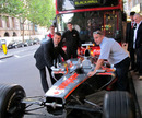 A McLaren MP4-23 is moved into the Waldorf Hilton Hotel conference room for the Formula 100 presentation
