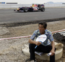 A construction worker fans himself as Karun Chandhok drives the new Korean Grand Prix circuit