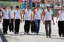 Adrian Sutil and Paul di Resta walk down the pit lane 