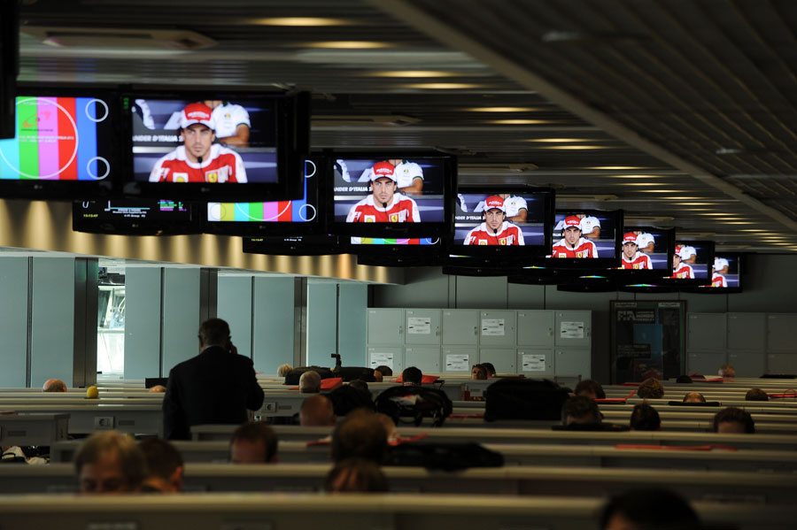 Journalists watch television screens during Thursday's press conference