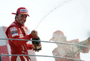Fernando Alonso sprays champagne on the podium