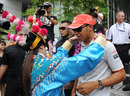 Lewis Hamilton is garlanded by a woman in traditional Chinese dress