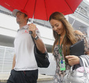 Jenson Button and Jessica Michibata arrive in the paddock