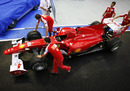 Fernando Alonso's Ferrari is pushed back to the Ferrari garage