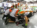 Force India mechanics work on Tonio Liuzzi's brakes