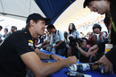 Sebastian Vettel signs an autograph for a fan