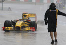 Robert Kubica ploughs through a puddle in the pit lane