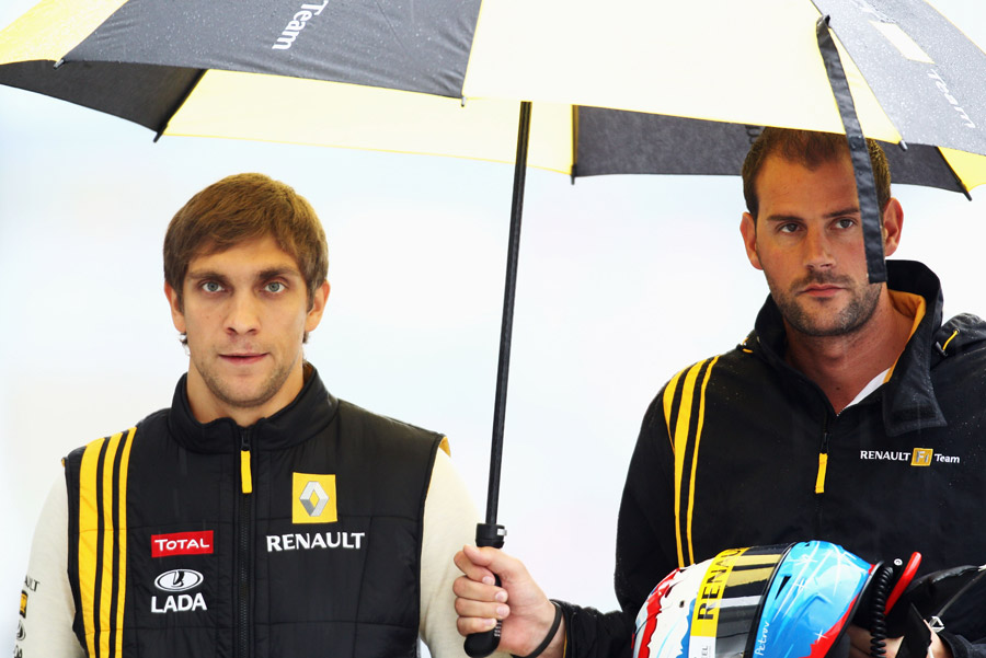 Vitaly Petrov takes shelter from the pouring rain