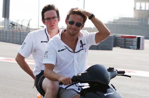 Jenson Button and race engineer Andy Shovlin ride a moped around Yas Marina