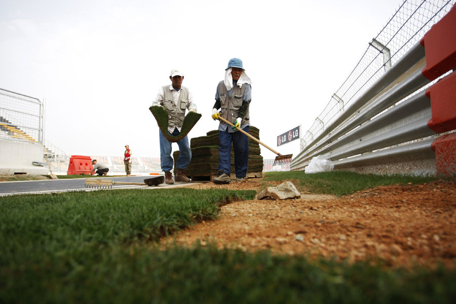Workers lay grass on the pit straight