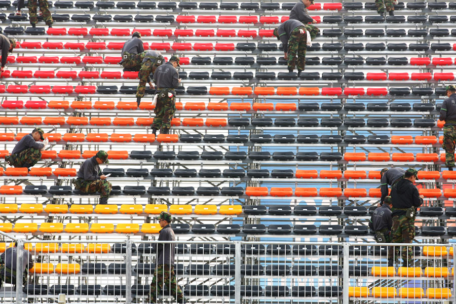 Workmen fill the grandstands with seats