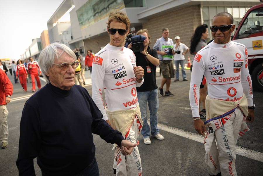Bernie Ecclestone walks with Jenson Button and Lewis Hamilton