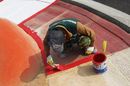 A worker finishes painting the kerbing