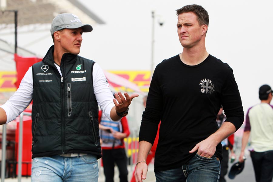 Michael Schumacher chats to brother Ralf in the paddock