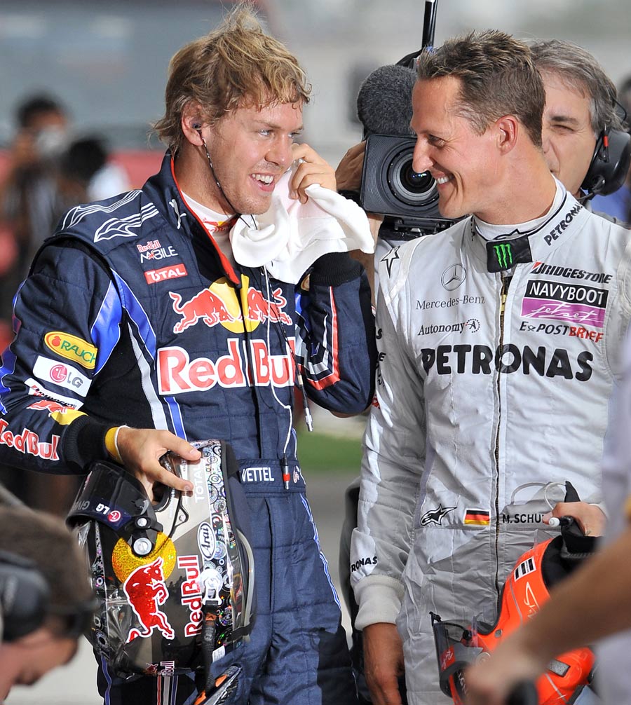 Sebastian Vettel shares a joke with Michael Schumacher