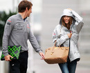 Jenson Button and Jessicia Michibata arrive in a wet paddock