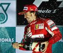 Fernando Alonso sprays champagne on the podium