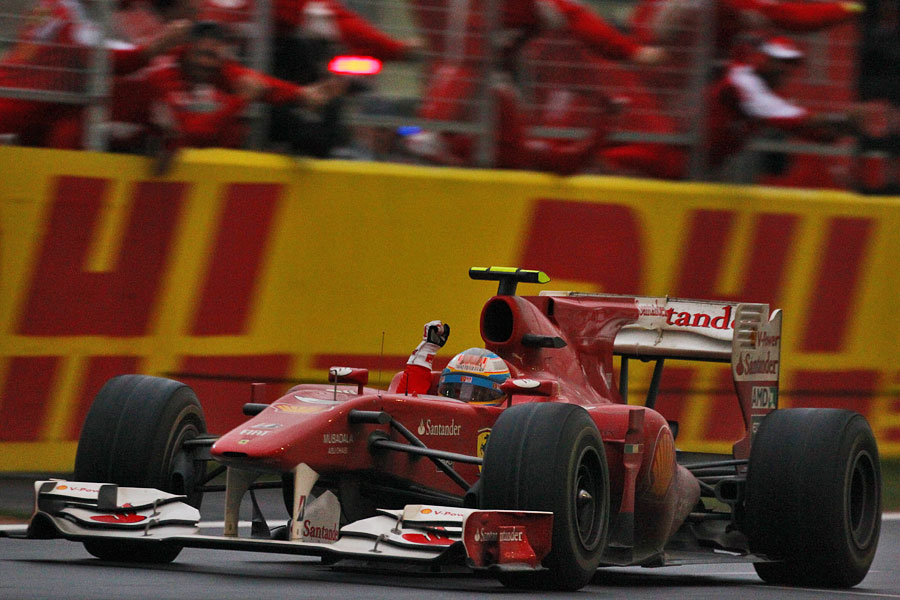 Fernando Alonso crosses the line to take victory