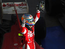 Fernando Alonso celebrates on top of his Ferrari