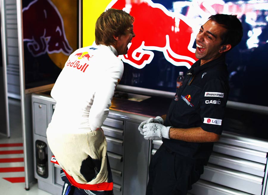 Sebastian Vettel shares a joke in the garage