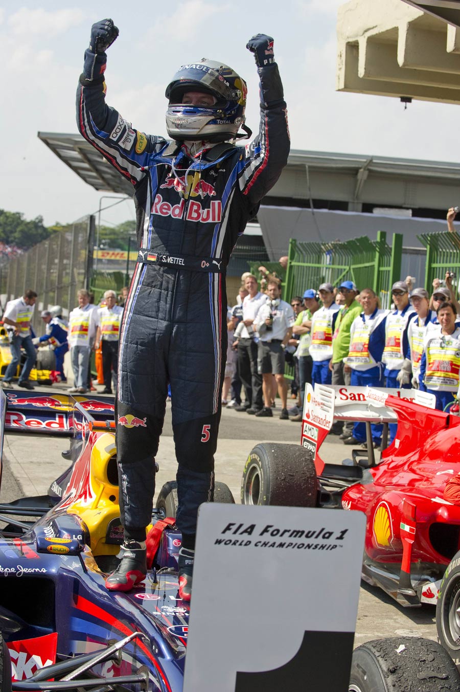 Sebastian Vettel stands on his car after winning the Brazilian Grand Prix