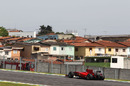 Fernando Alonso flashes past local houses
