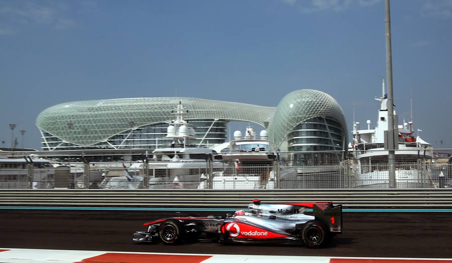 Jenson Button drives past the Yas Hotel