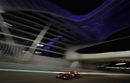 Lewis Hamilton drives under the Yas Hotel bridge at night