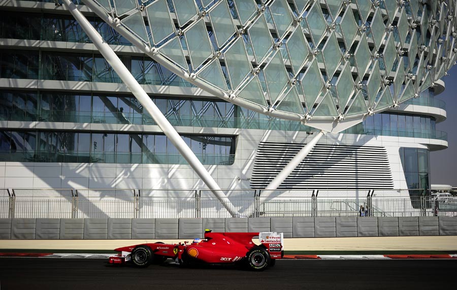 Fernando Alonso flashes past the Yas Hotel