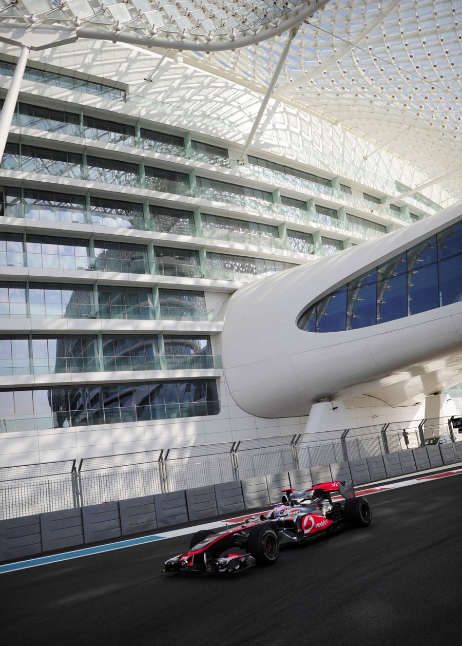 Jenson Button passes underneath the Yas Hotel bridge