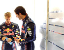 Sebastian Vettel and Mark Webber chat at the back of the Red Bul garage