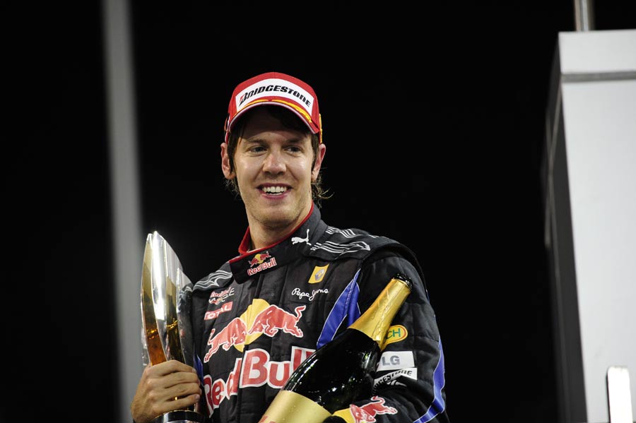 Sebastian Vettel with his trophy and champagne on the podium