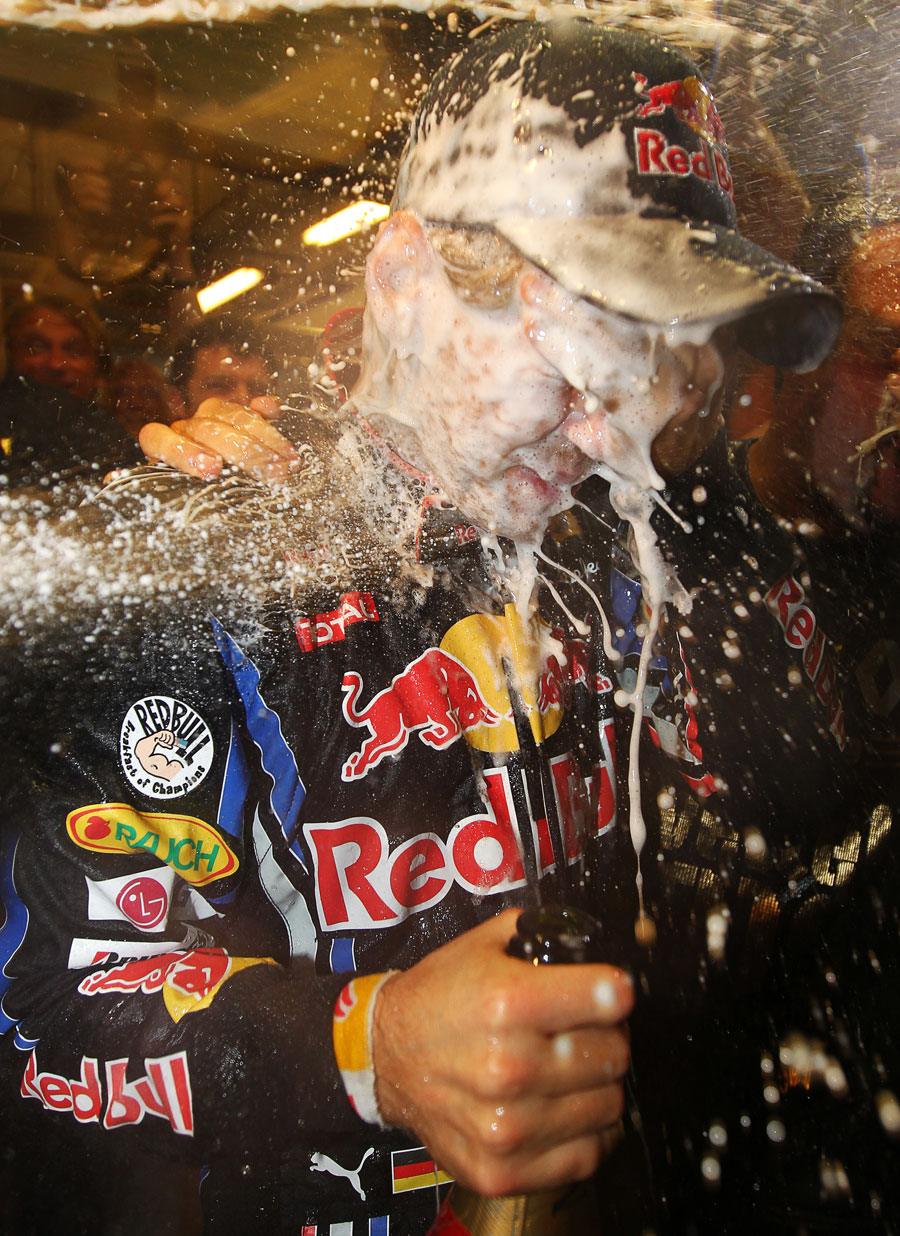 Sebastian Vettel gets doused with champagne in the Red Bull garage