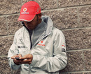 Lewis Hamilton uses his phone in the paddock