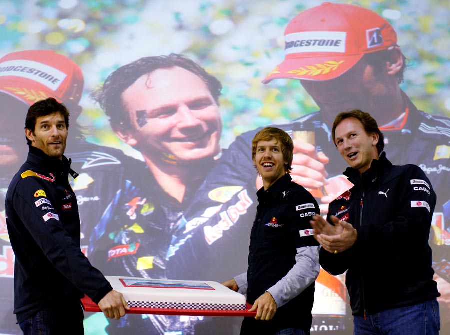Sebastian Vettel and Mark Webber give a birthday cake to team principal Christian Horner