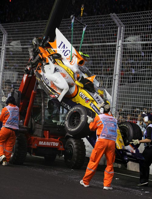 Nelson Piquet Jnr's car is retrieved after he crashed into the wall