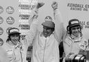 Ken Tyrrell celebrates on the podium with drivers Jackie Stewart and Francois Cevert