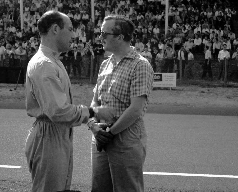 Stirling Moss chats to Lotus team boss Colin Chapman on the pit straight at Zandvoort 
