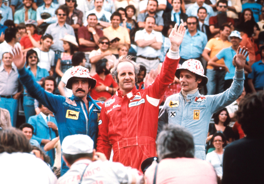 Denny Hulme, flanked by Clay Regazzoni and Niki Lauda, takes the plaudits