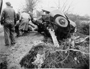 Police and mechanics probe the wreckage of the sports car in which Britain's Mike Hawthorn met his death