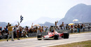 Carlos Reutemann  takes the chequered flag to secure his first race win