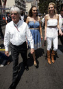 Bernie Ecclestone leads his daughters Tamara and Petra down the pit lane