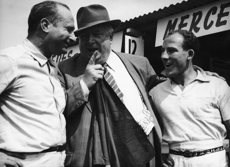Alfred Neubauer,  manager of the German Mercedes team, has a word with Juan Manuel Fangio and Stirling Moss