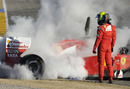Felipe Massa stands to one side as his Ferrari smoulders
