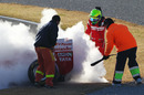 Marshals put out the fire at the rear of Felipe Massa's car