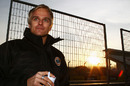 Heikki Kovalainen enjoys an early-morning coffee while team-mate Jarno Trulli heads out in the Lotus