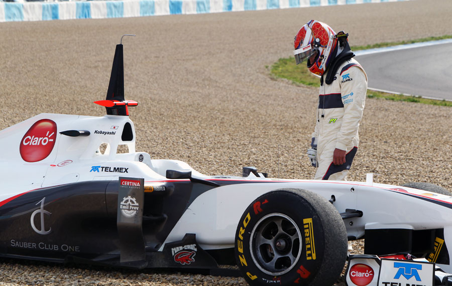 A rueful Kamui Kobayashi looks at his Sauber as it sits in the gravel
